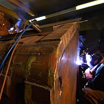 Welder working on mining equipment