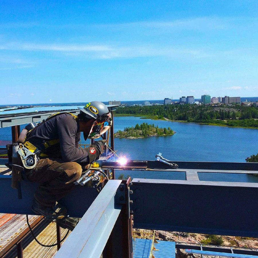 Welder working on a beam high up