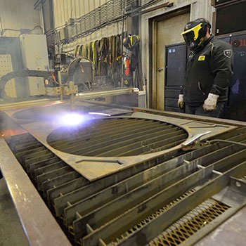 Welder in mask watching CNC